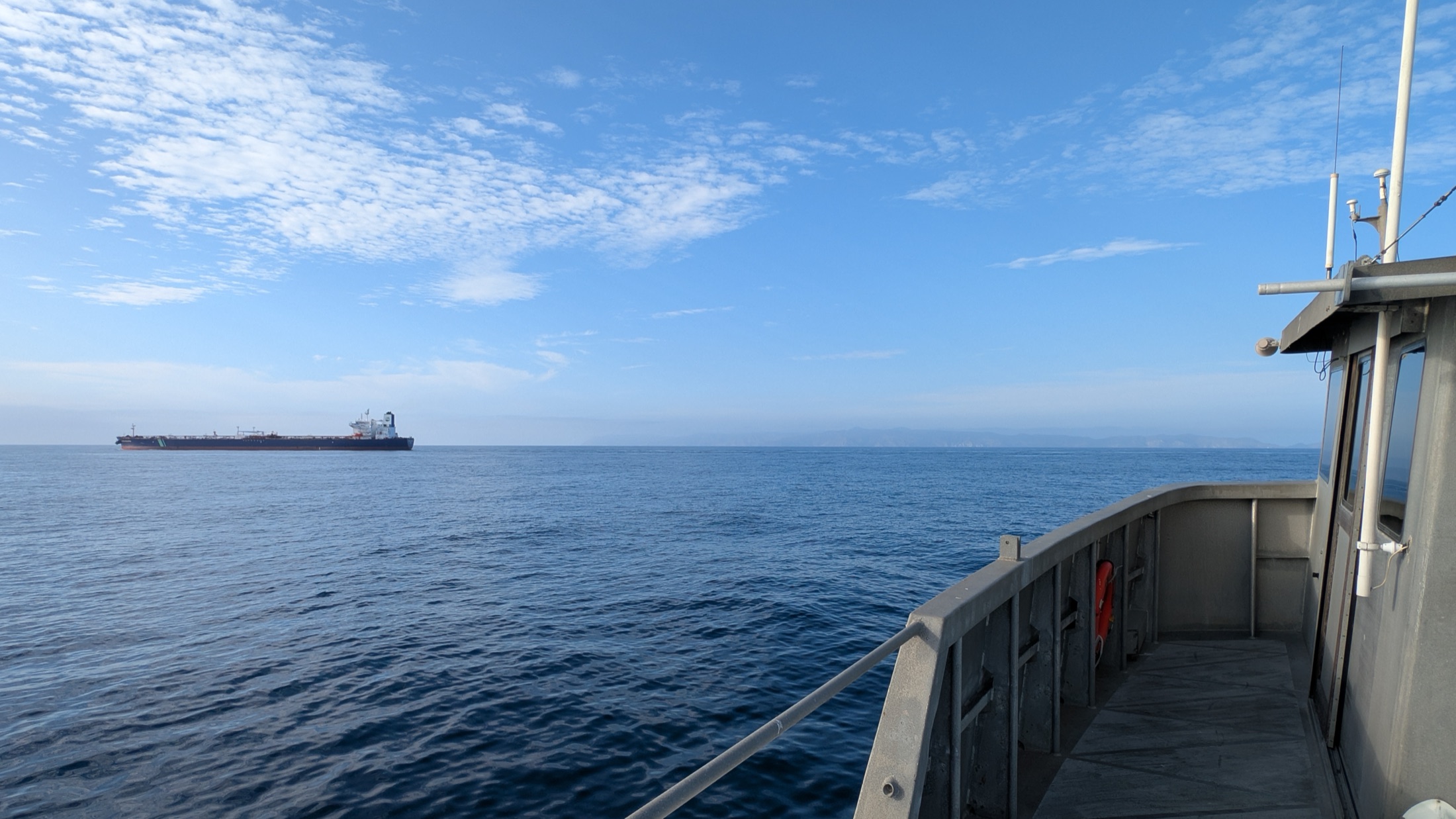 Open ocean and a cargo ship viewed from a research vessel