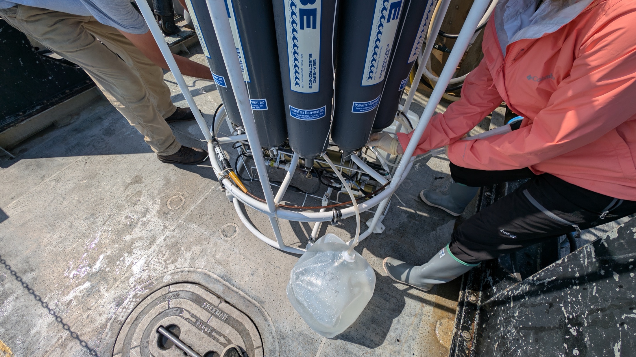 A researcher collecting seawater from a CTD rosette