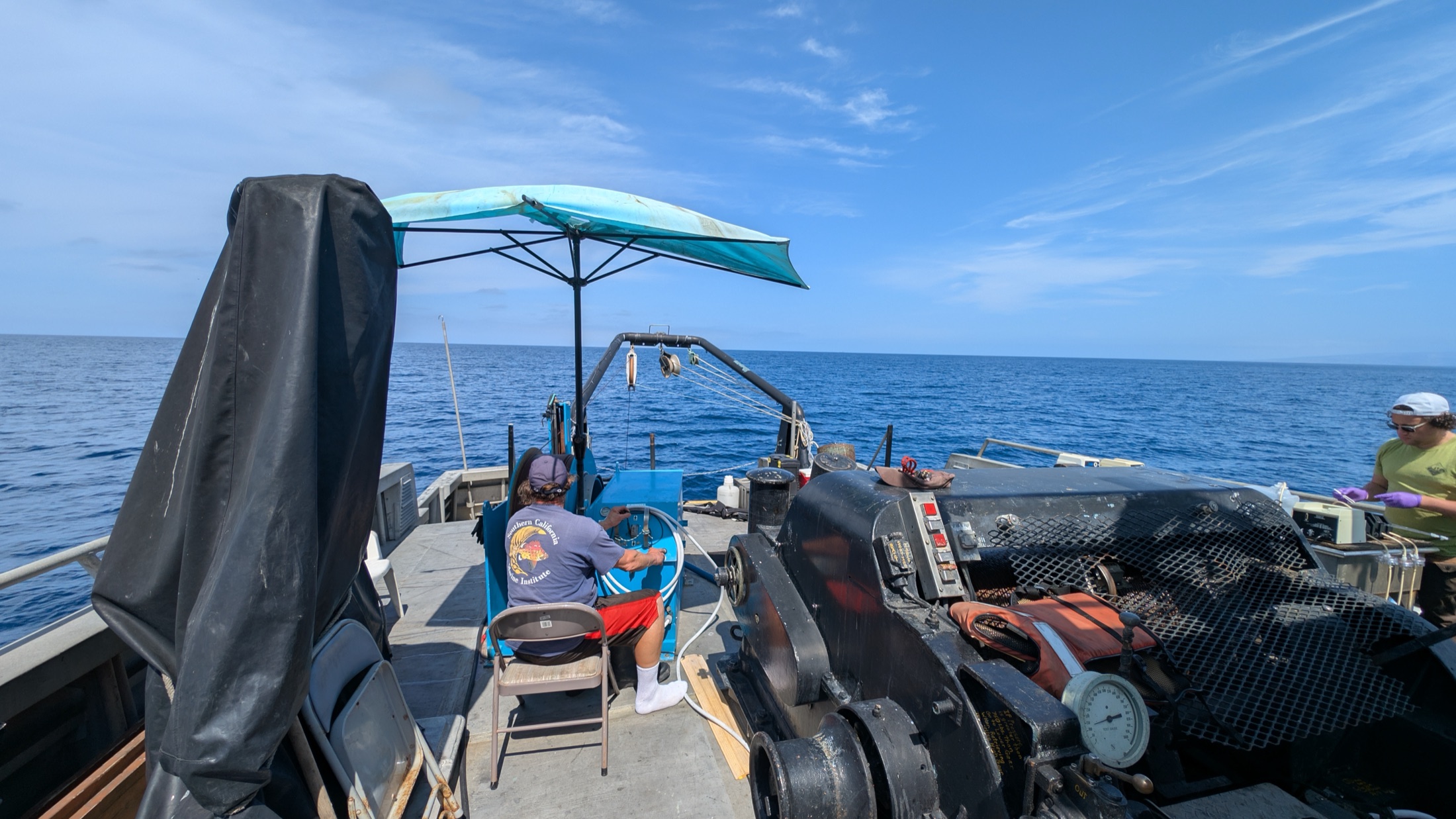 Researchers working with oceanographic equipment on the deck of a research vessel