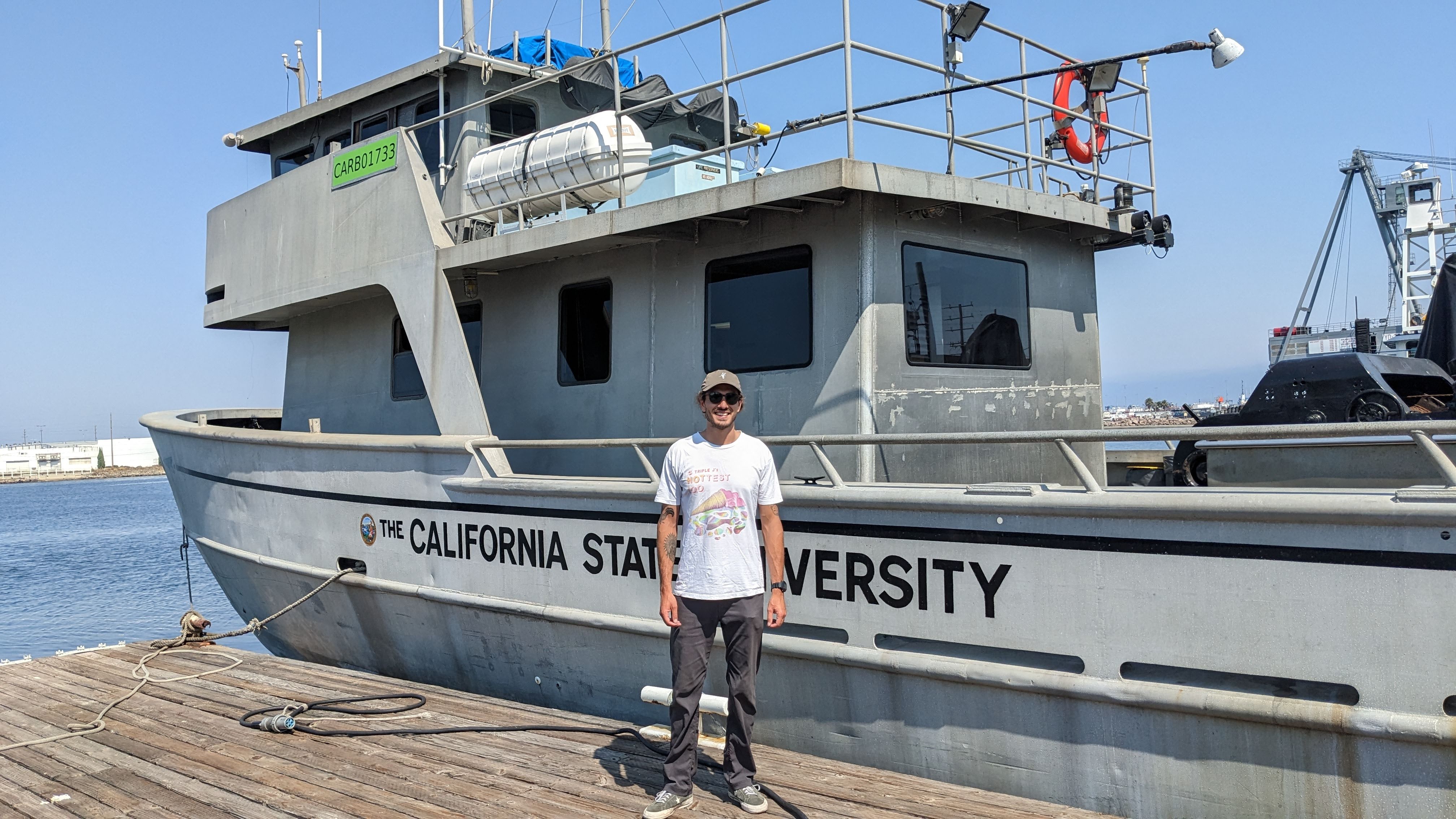 Nathan Williams standing beside a research vessel