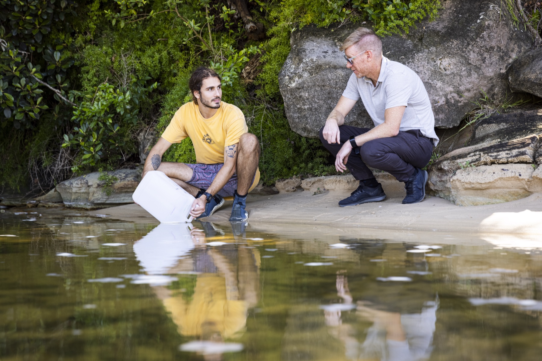 Researchers collecting water samples along a shoreline